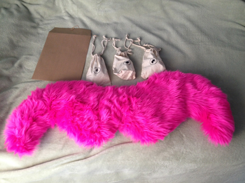 box for a new lyft driver containing a pink mustache and bags of phone chargers