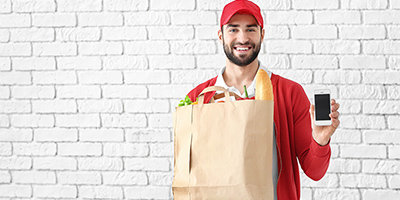 man holding a delivery bag and smartphone