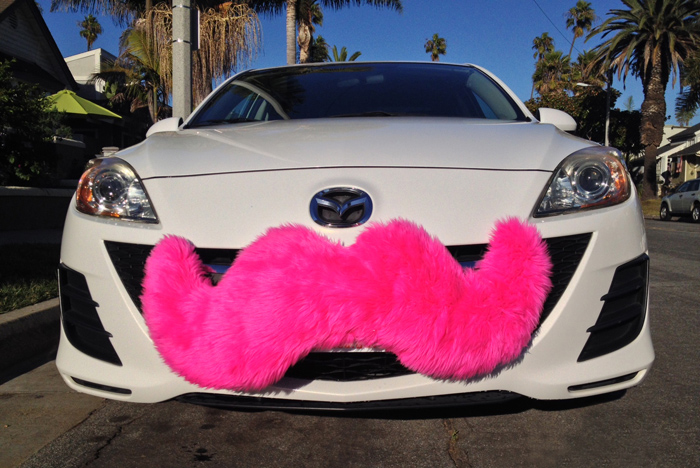 Car with a pink Lyft mustache on the front grille