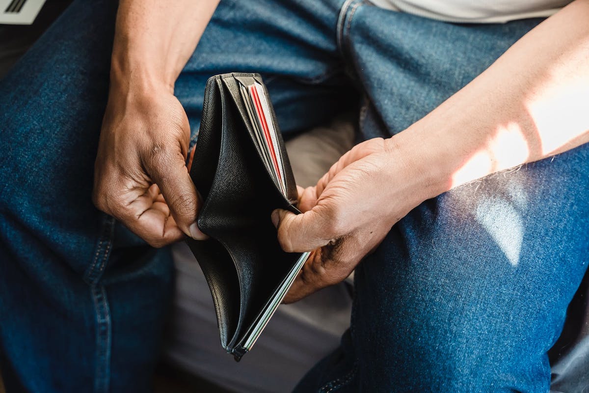 a person holding open an empty wallet