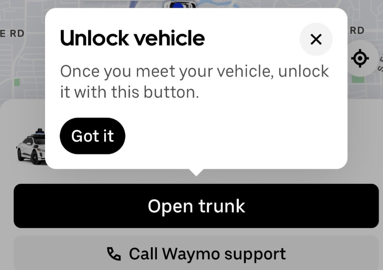 instructions to press a button to unlock a waymo vehicle for an uber eats delivery